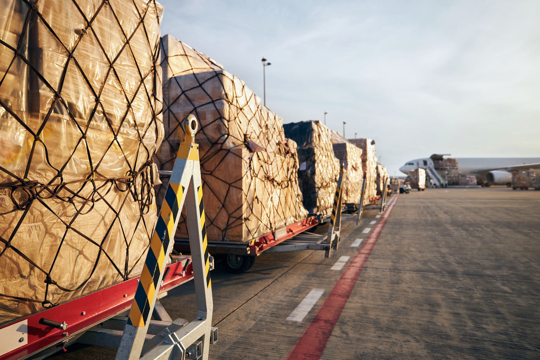 Loading of cargo containers to airplane at airport.