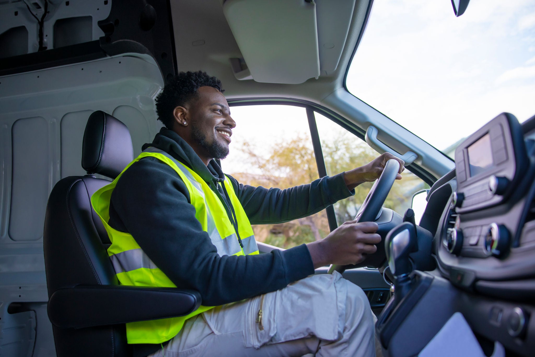 An African American man making deliveries from his cargo van on a sunny day.