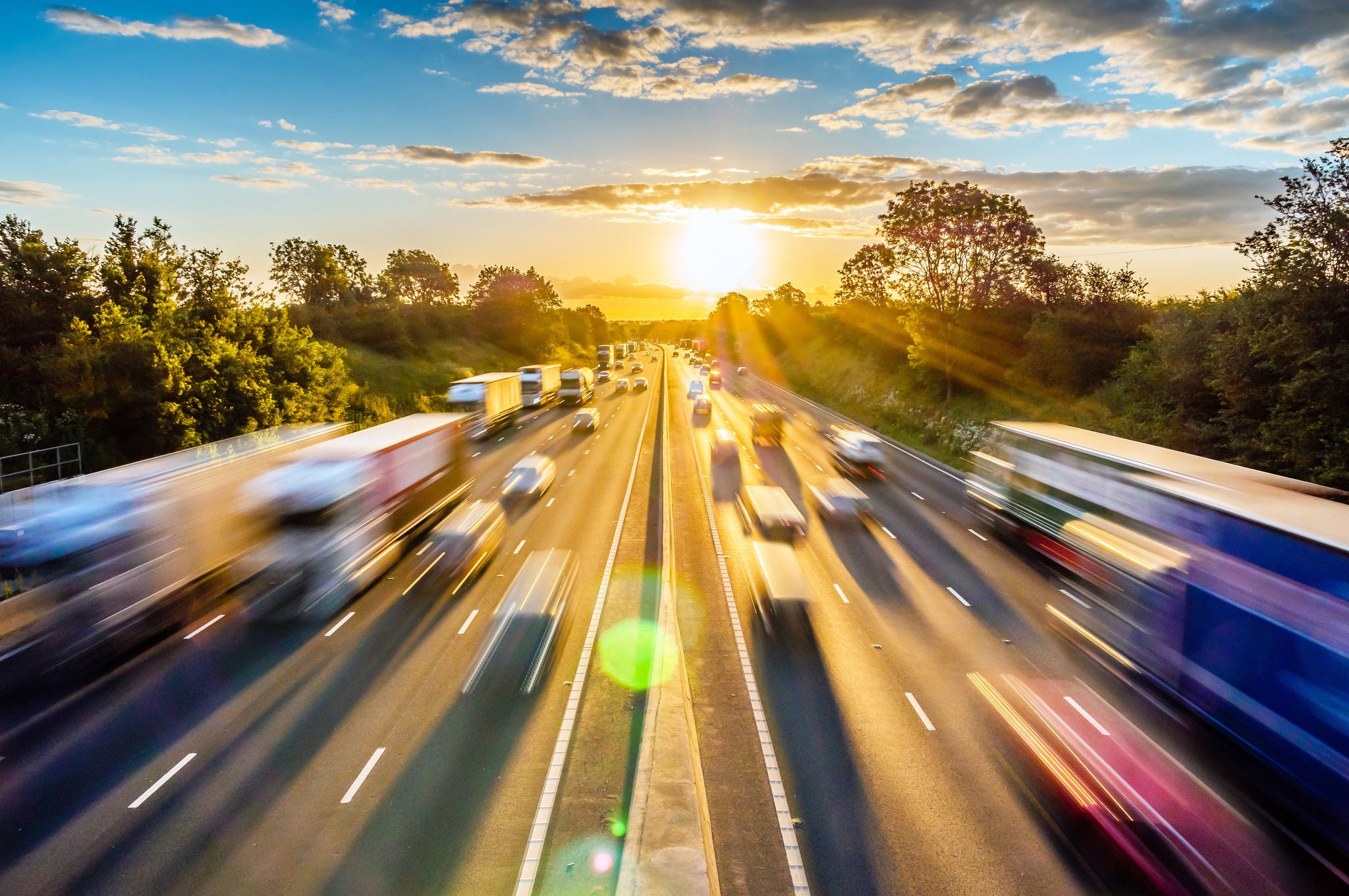 heavy traffic moving at speed on UK motorway in England at sunset.