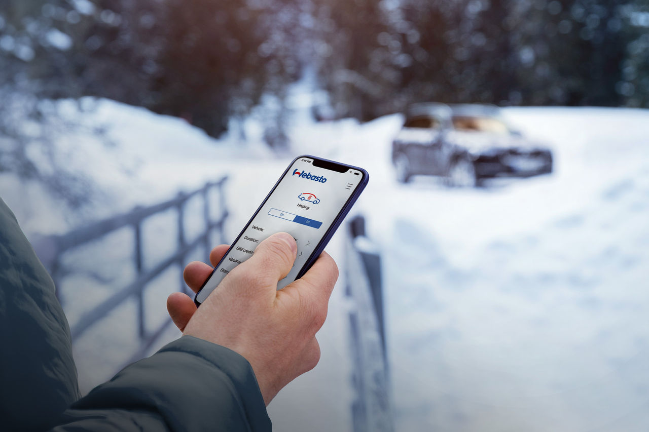 Heating control devices header Person holding a phone with Webasto ThermoConnect